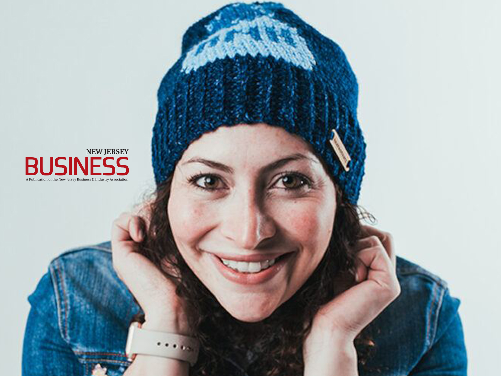 New Jersey Business logo overlaid on image of Shira in blue hat